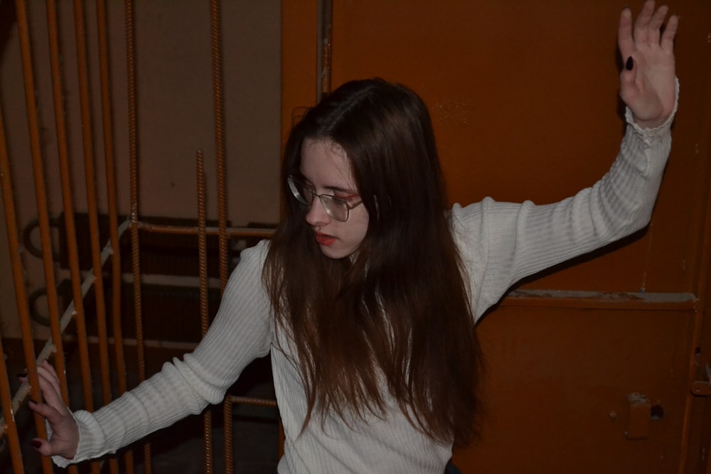 a woman with glasses standing in front of a gate