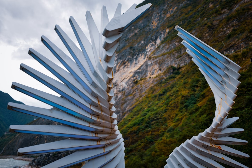 a close up of a metal sculpture near a body of water