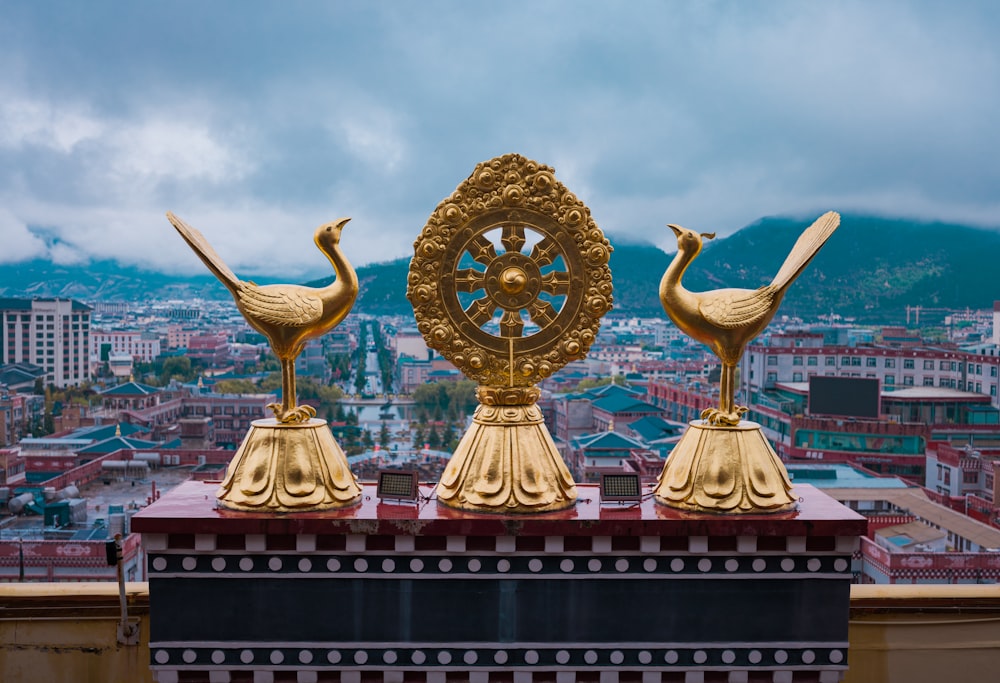 three golden statues on top of a building