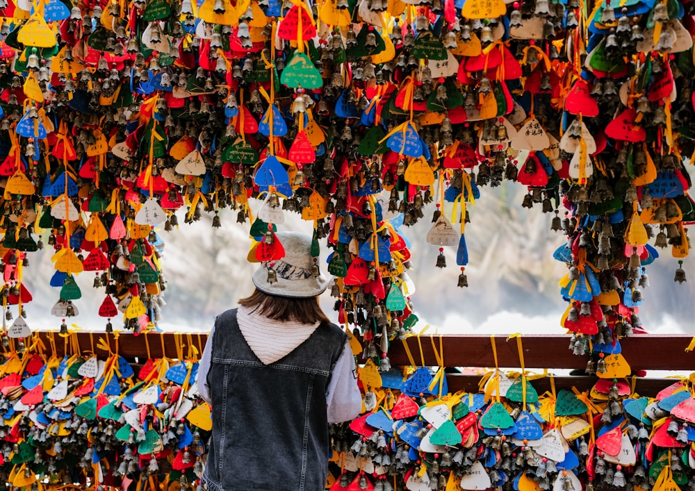 a woman standing under a colorful display of handmade items
