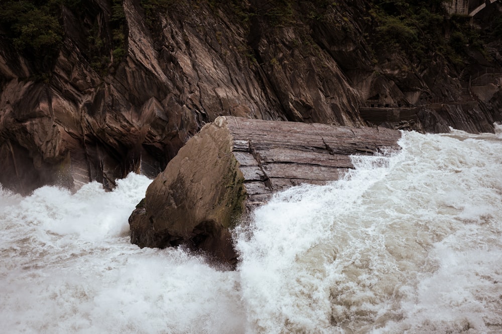 a large rock in the middle of a body of water