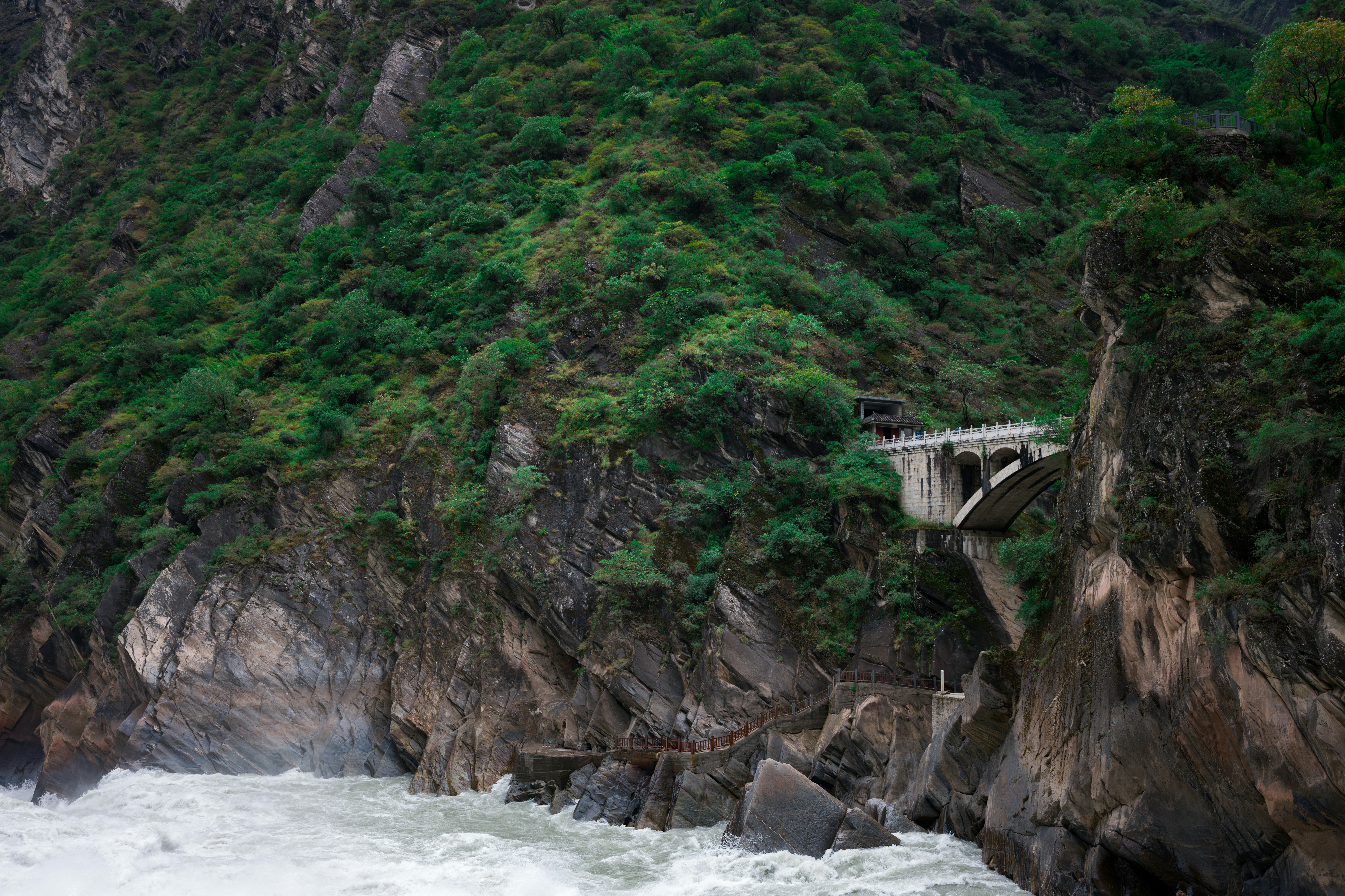 a bridge over a body of water near a mountain