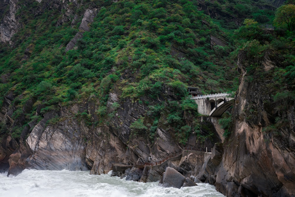 a bridge over a body of water near a mountain