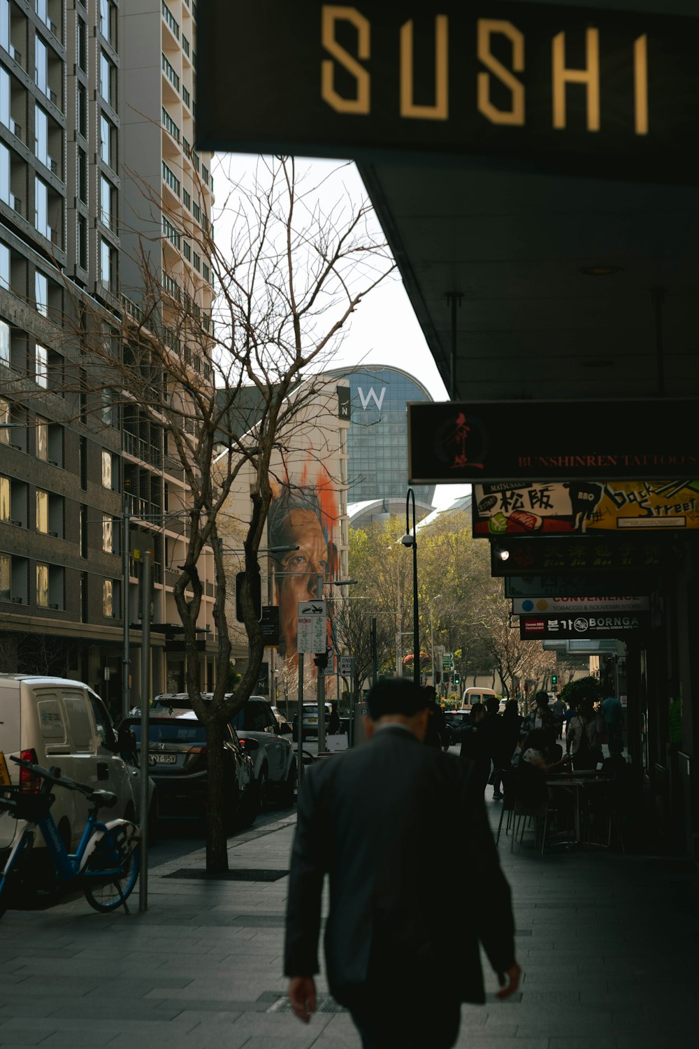 a man walking down a street next to tall buildings