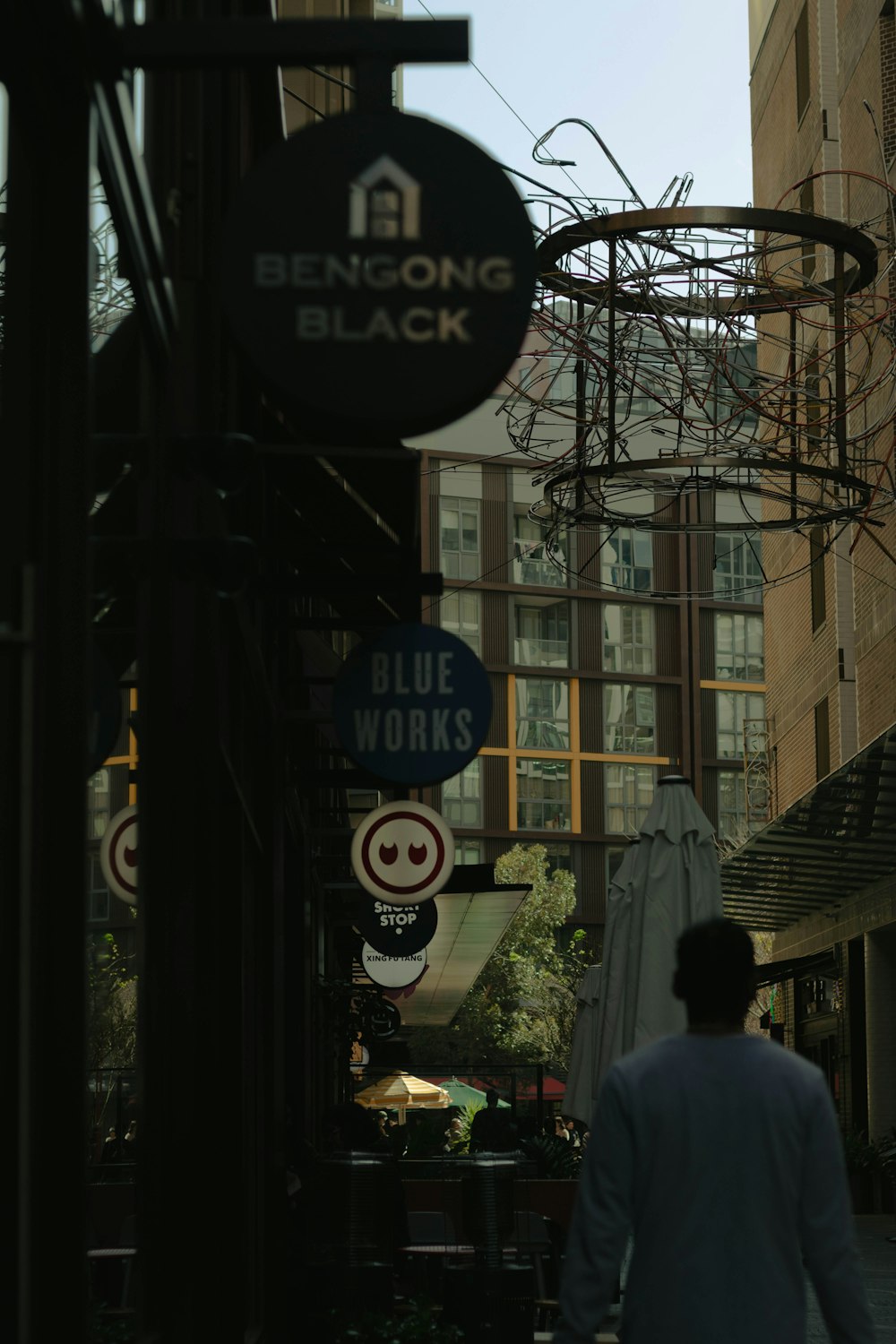 a man walking down a street next to tall buildings