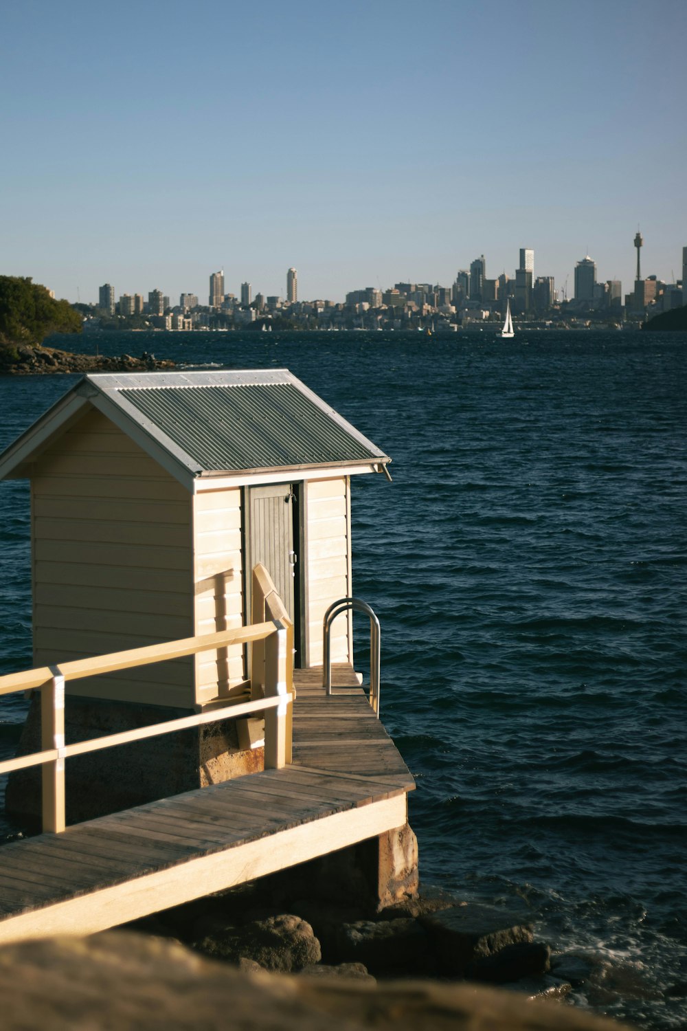 ein kleines Haus, das auf einem Pier neben einem Gewässer sitzt