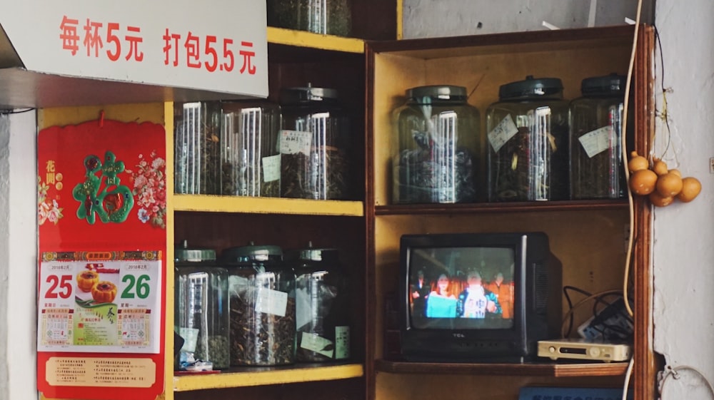 a television sitting on top of a wooden shelf