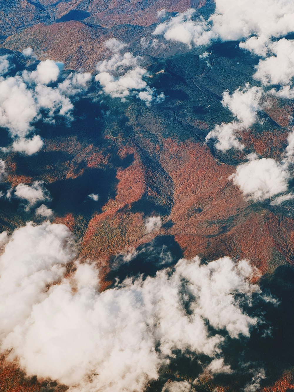 an aerial view of a mountain range and clouds