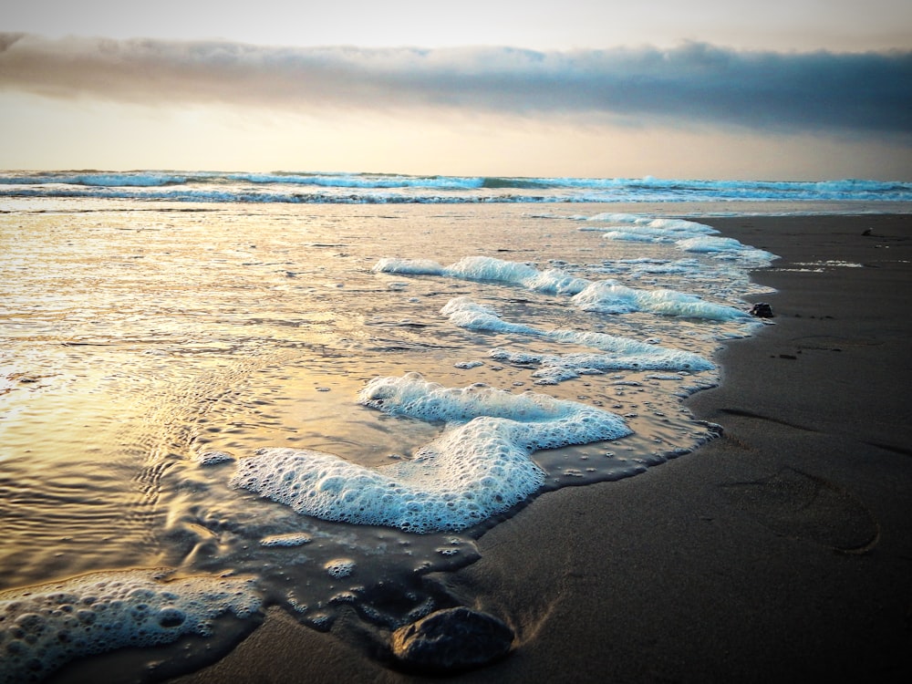 a sandy beach with waves coming in to shore