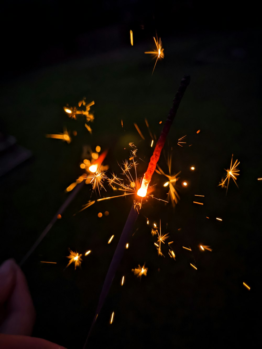 a person holding a lit sparkler in their hand