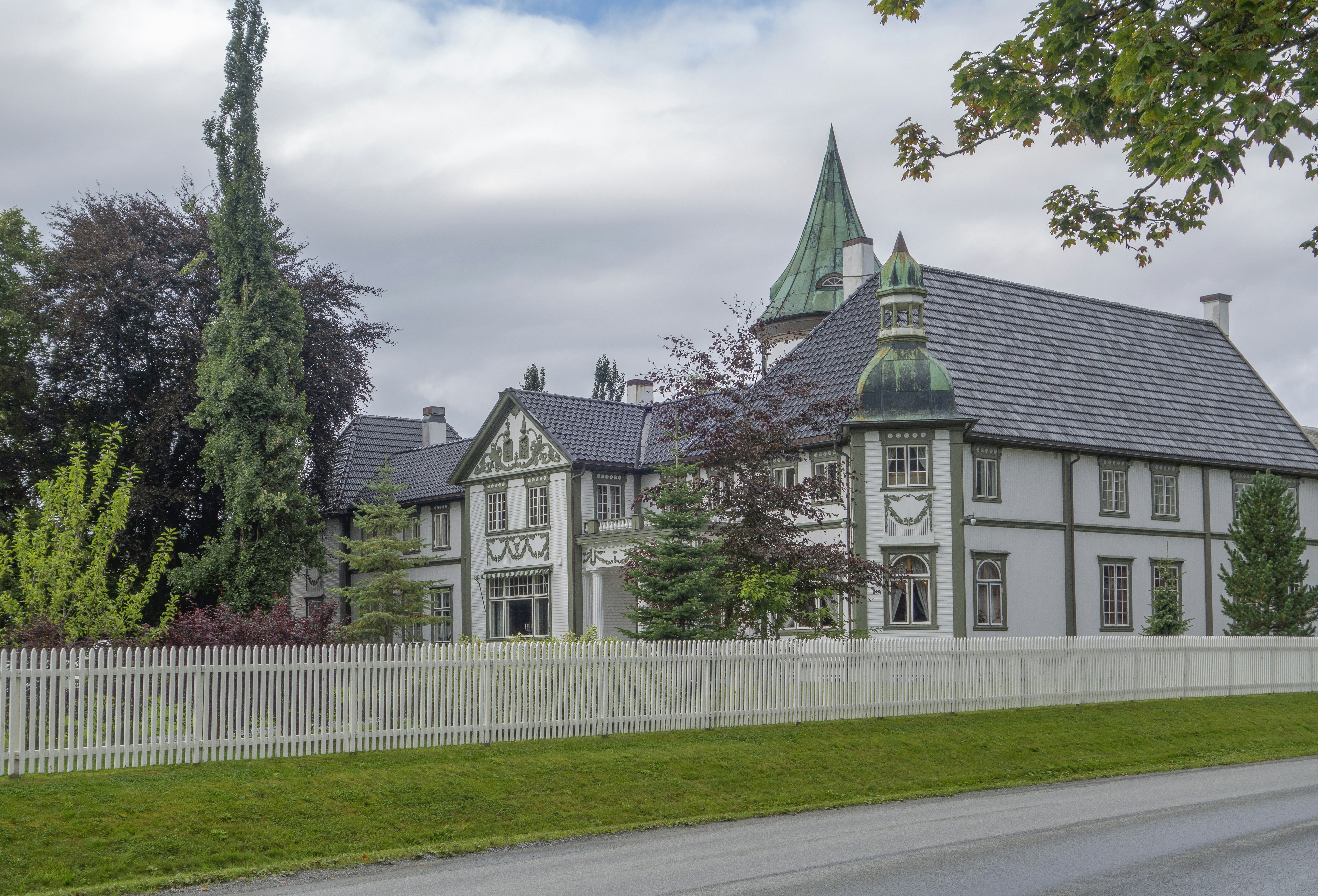 a large white house with a clock on the front of it