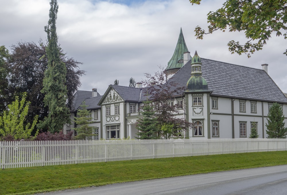 a large white house with a clock on the front of it