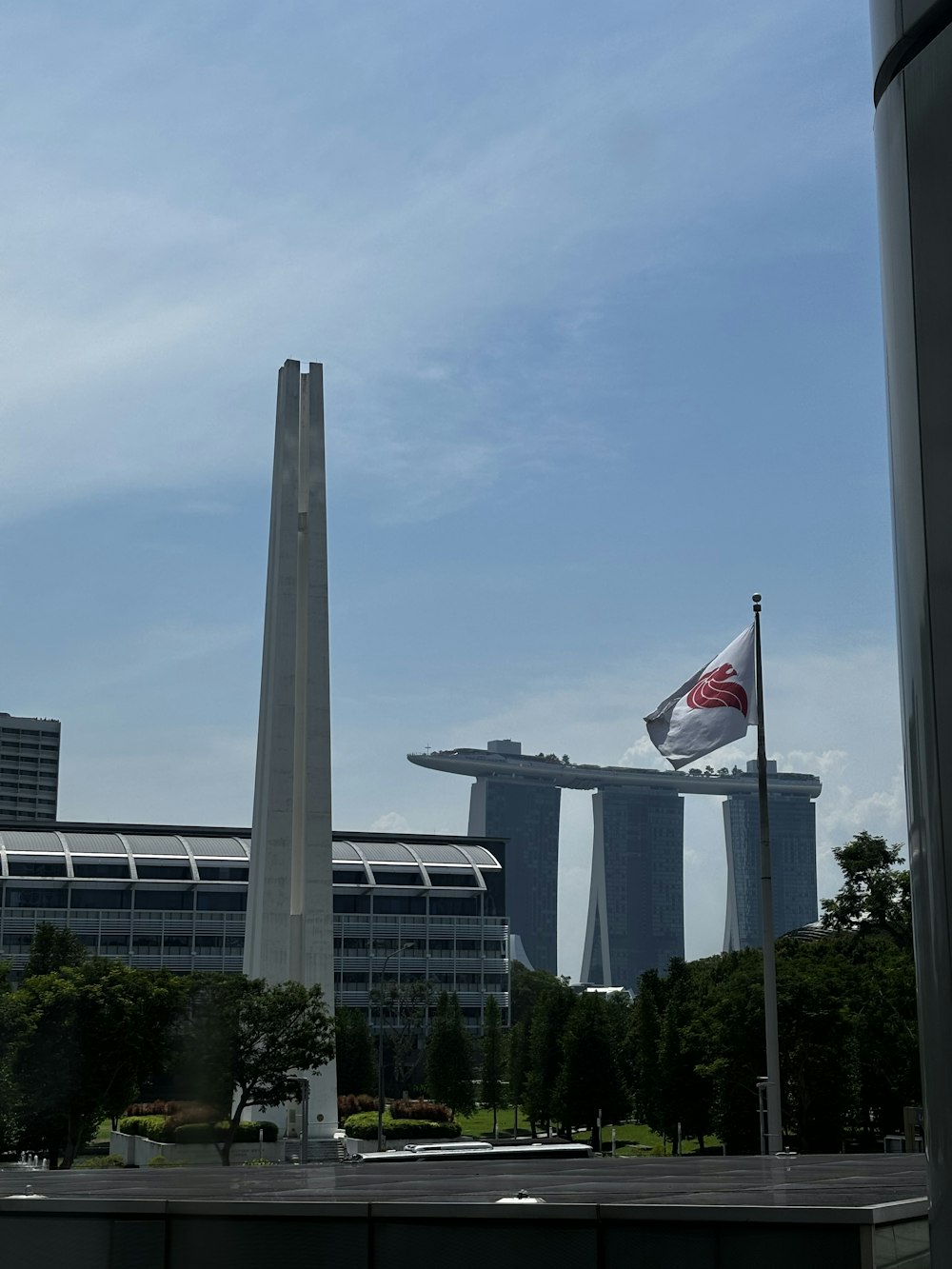 Una vista de un edificio muy alto con una bandera ondeando frente a él