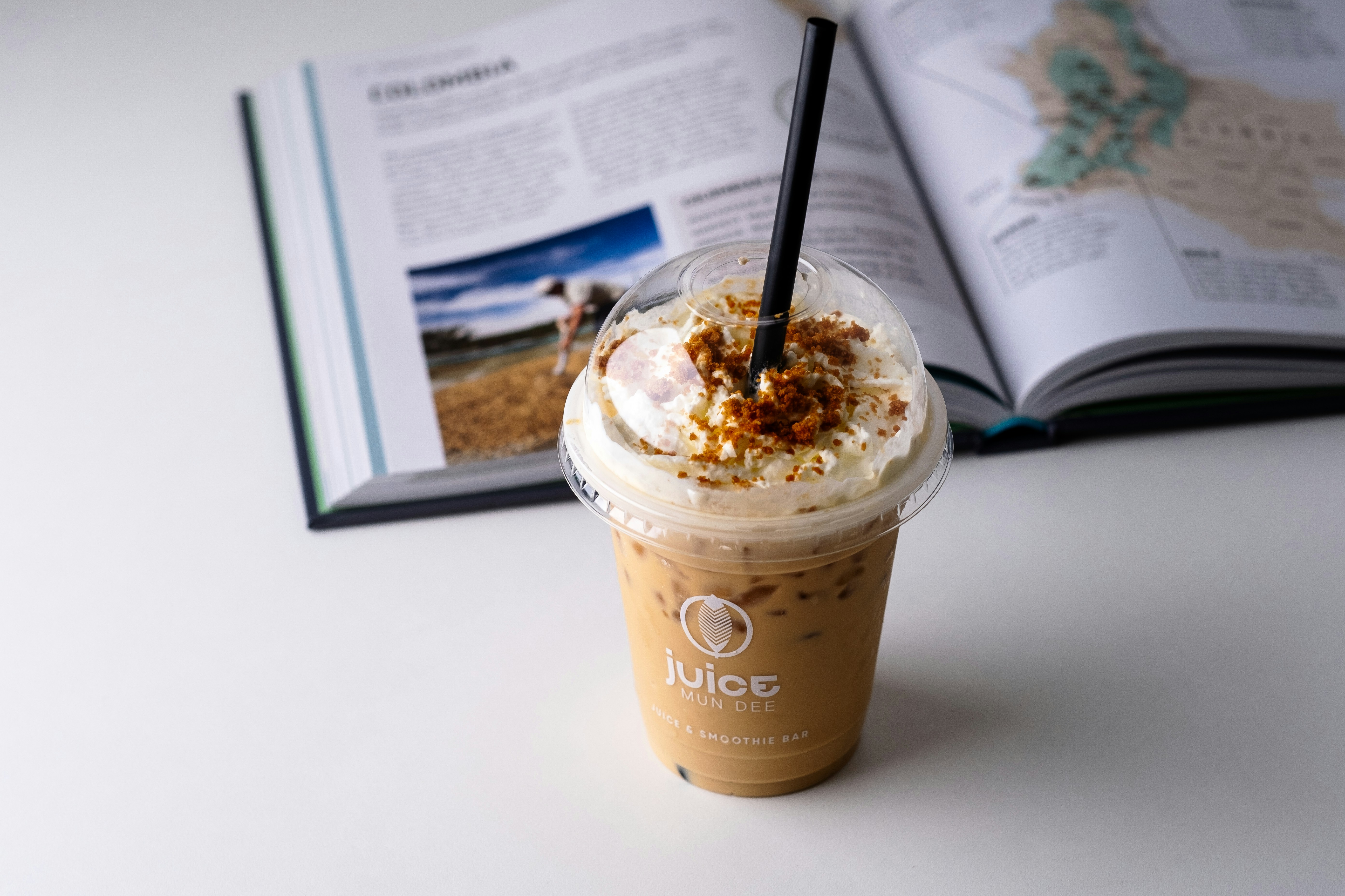 a cup of coffee sitting next to an open book