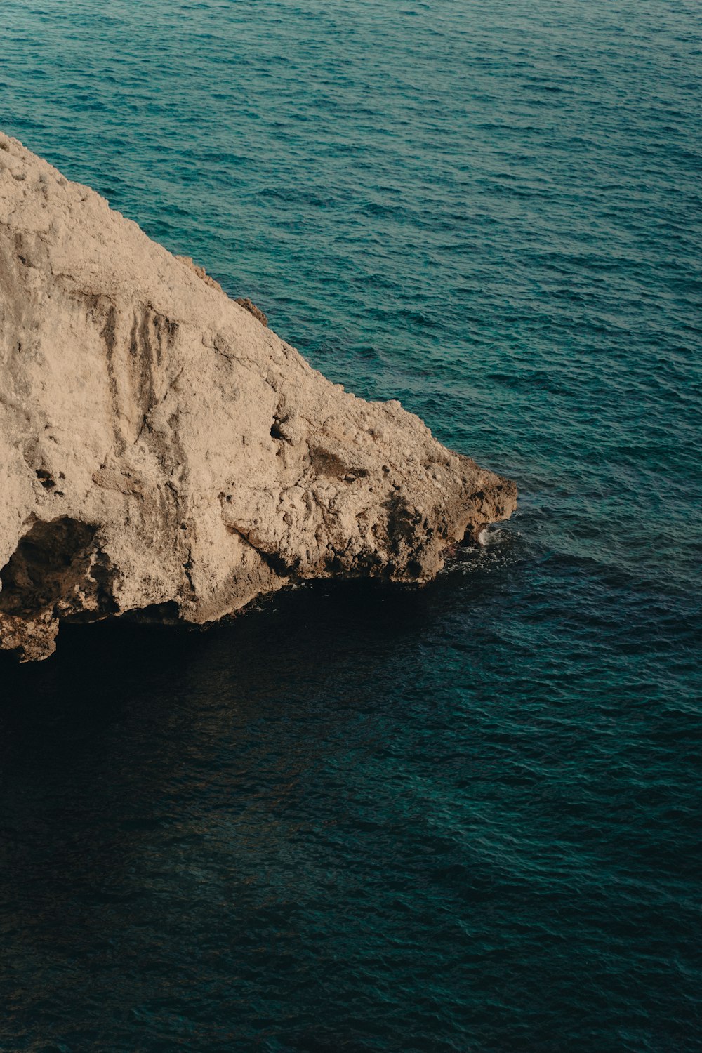 a large rock sticking out of the water