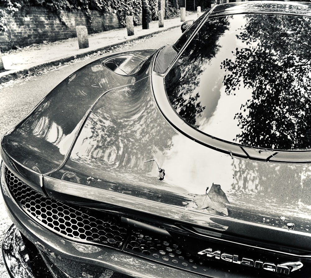 a black and white photo of a car parked on the side of the road