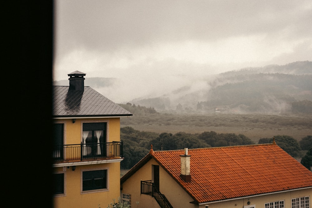 a house with a red roof and a mountain in the background