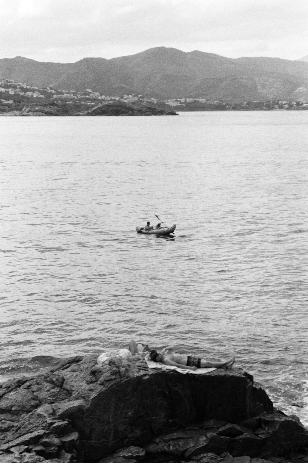 a black and white photo of two people in a boat