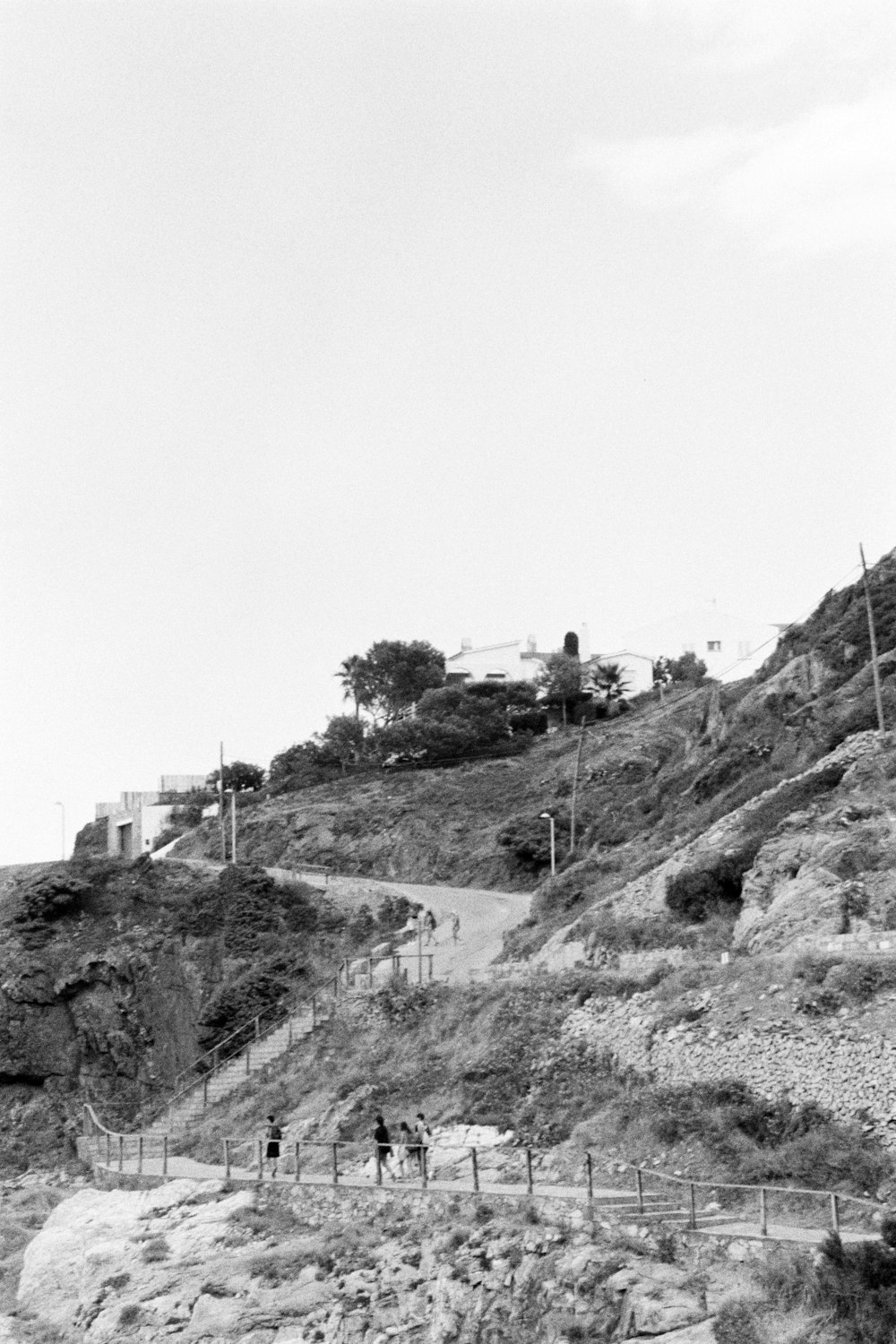 a black and white photo of people walking up a hill