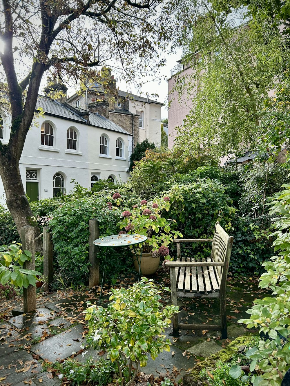 a wooden bench sitting in the middle of a garden