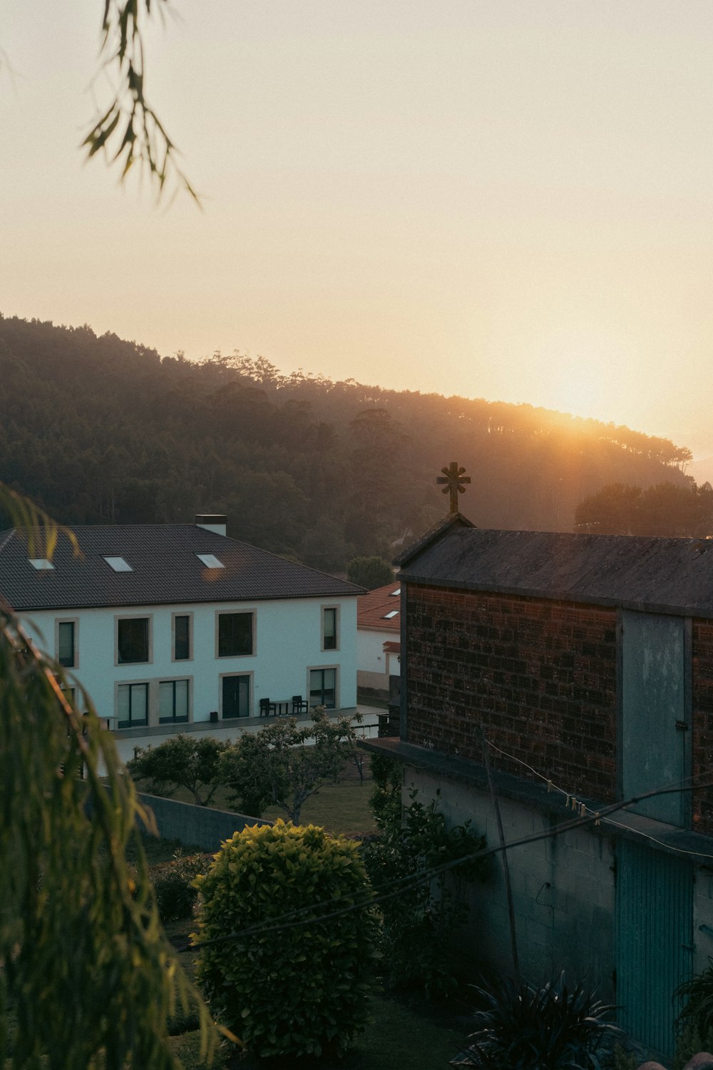 the sun is setting over a building in the distance