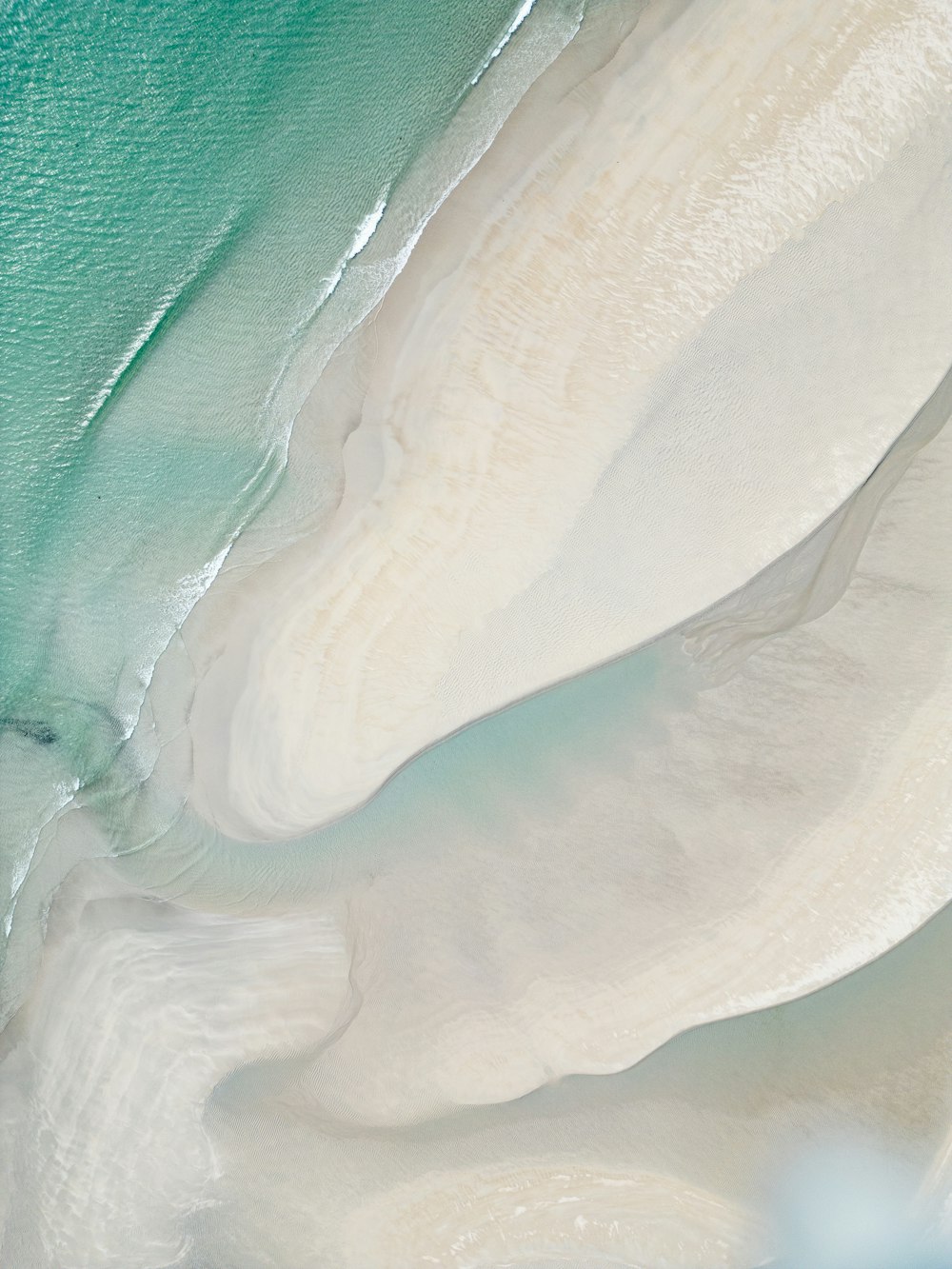 an aerial view of a sandy beach and ocean