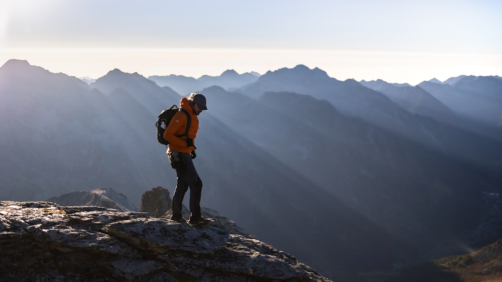 a man standing on top of a mountain with a backpack