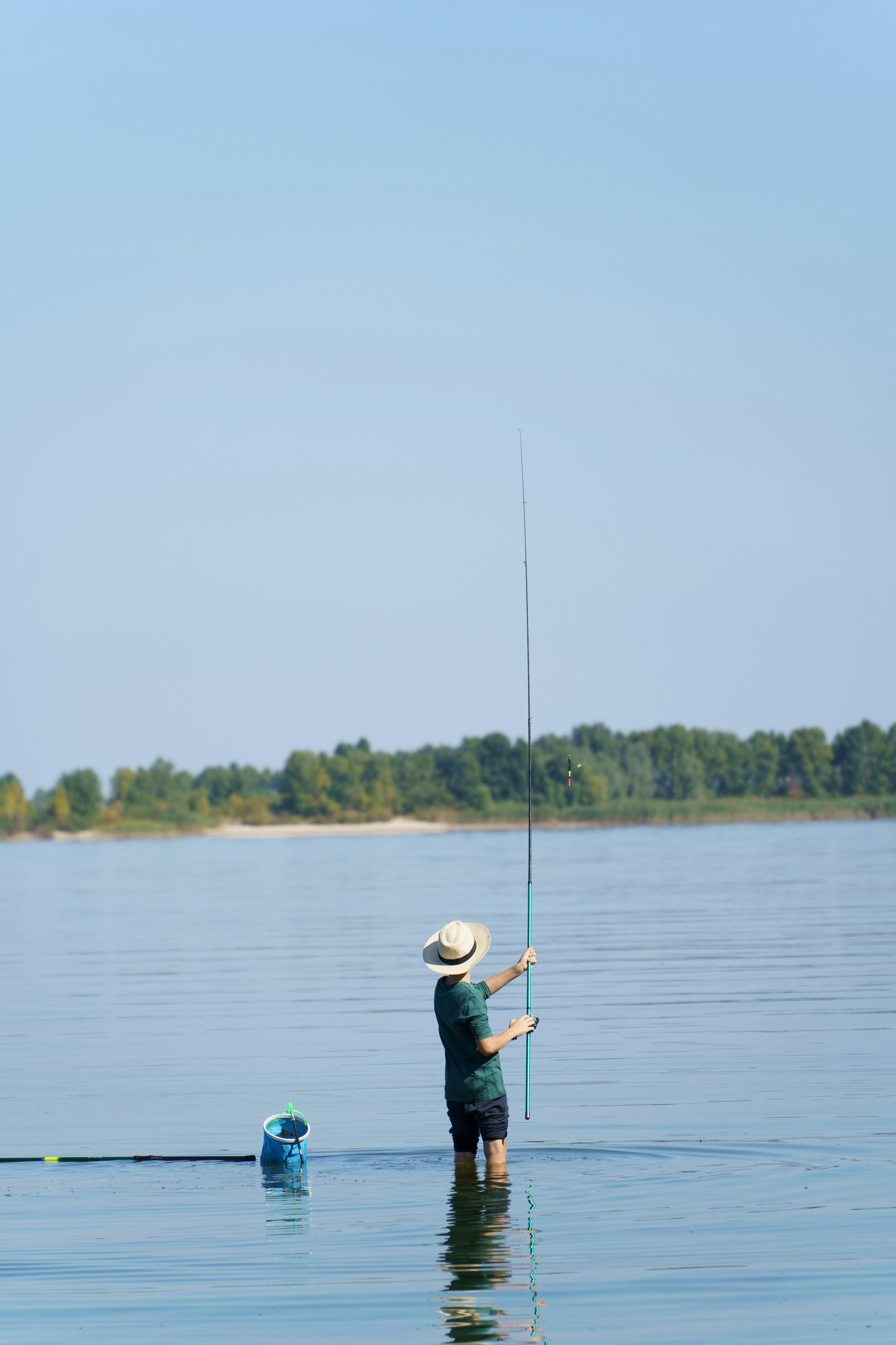 a man standing in the water holding a fishing pole