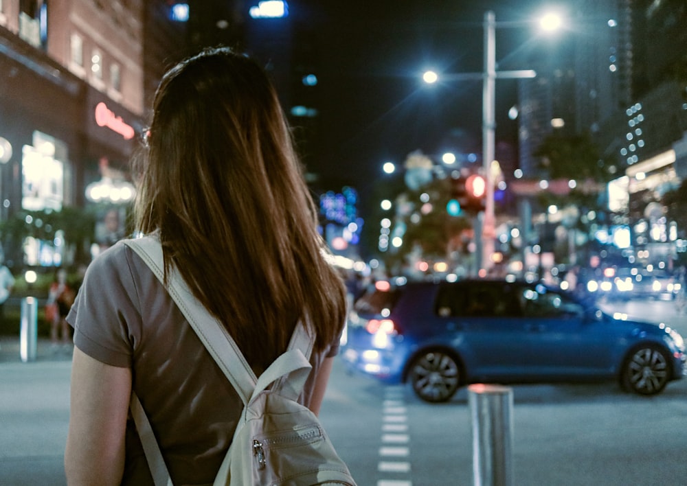 a woman walking down a street at night