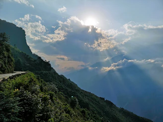 the sun shines through the clouds over the mountains