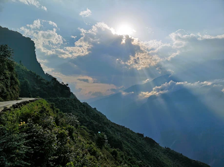 the sun shines through the clouds over the mountains
