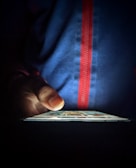 Close-up of a person scrolling through a dark-themed curiosity blog on a smartphone.