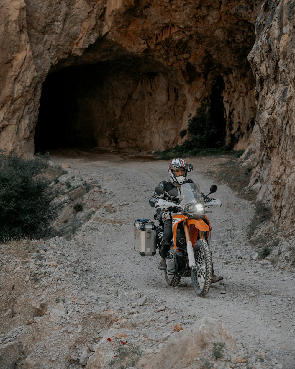 a motorcycle parked in front of a cave