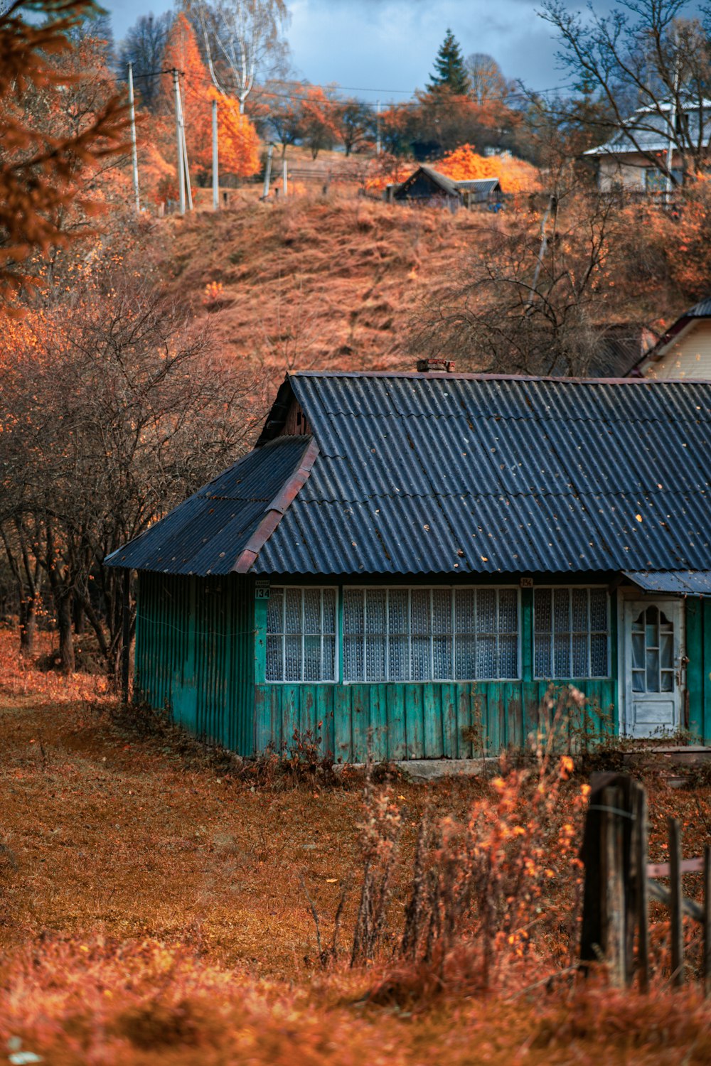 una pequeña casa verde con techo negro