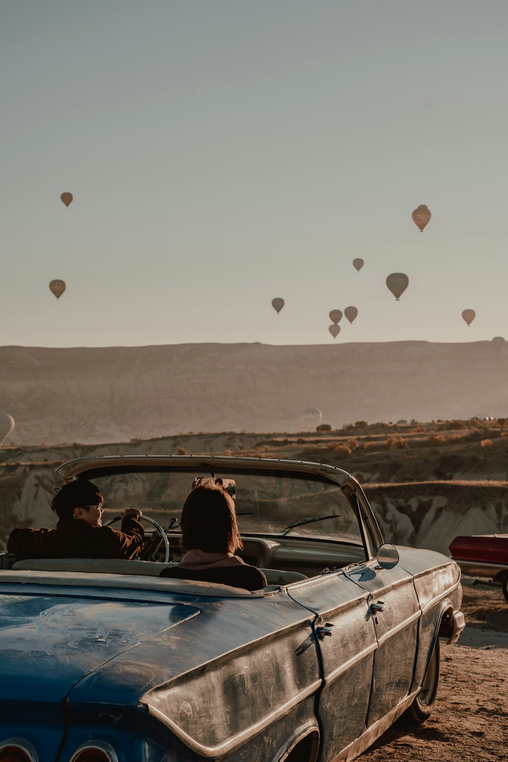 a group of people riding in a convertible car