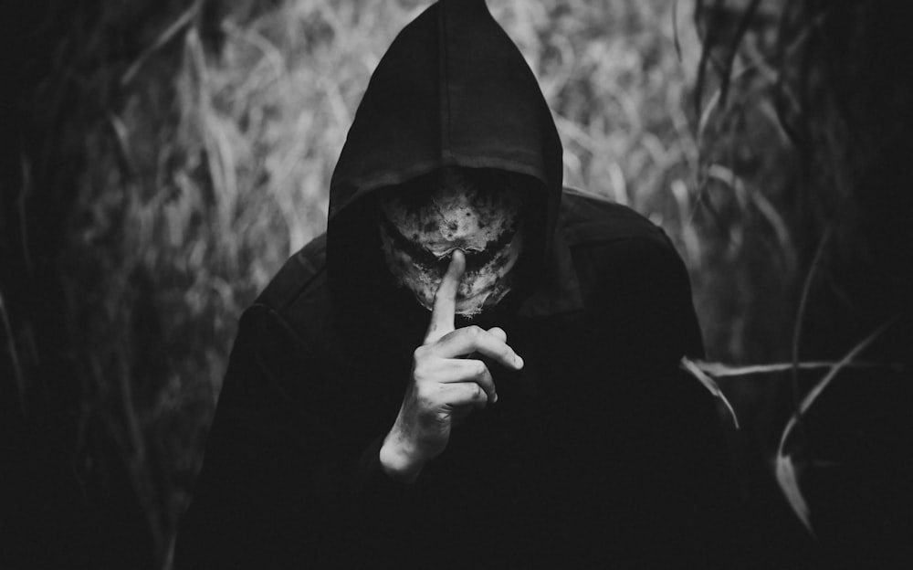a person in a hooded jacket smoking a cigarette