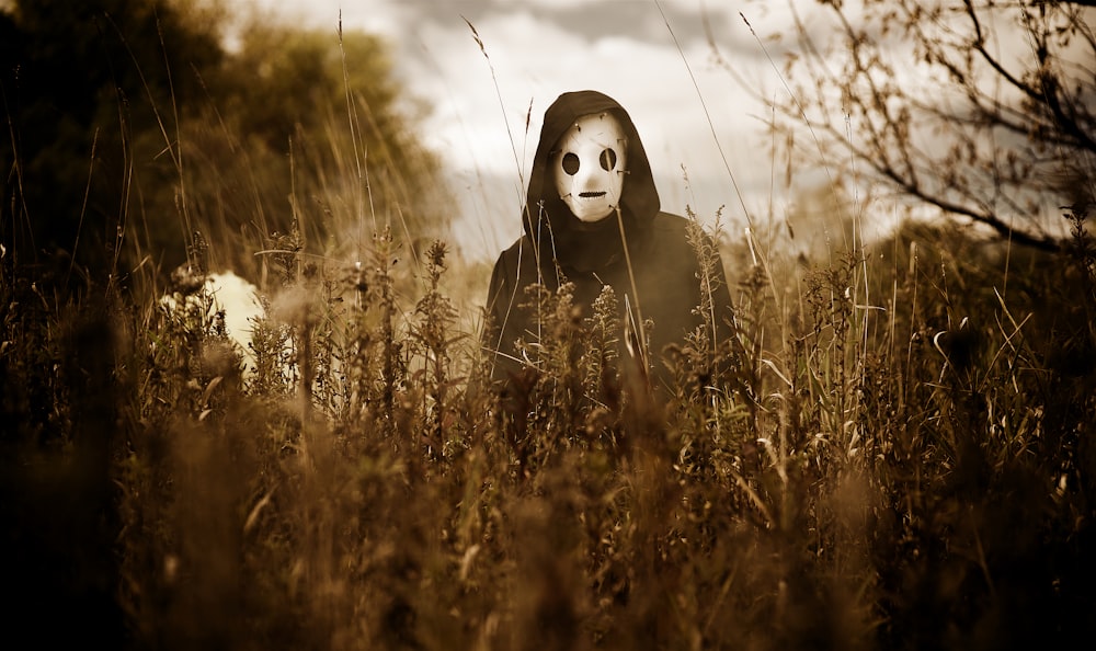a person wearing a mask in a field of tall grass