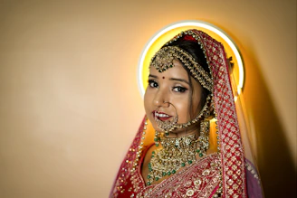 A bride glowing with expertly applied makeup and intricate mehendi designs on her hands.