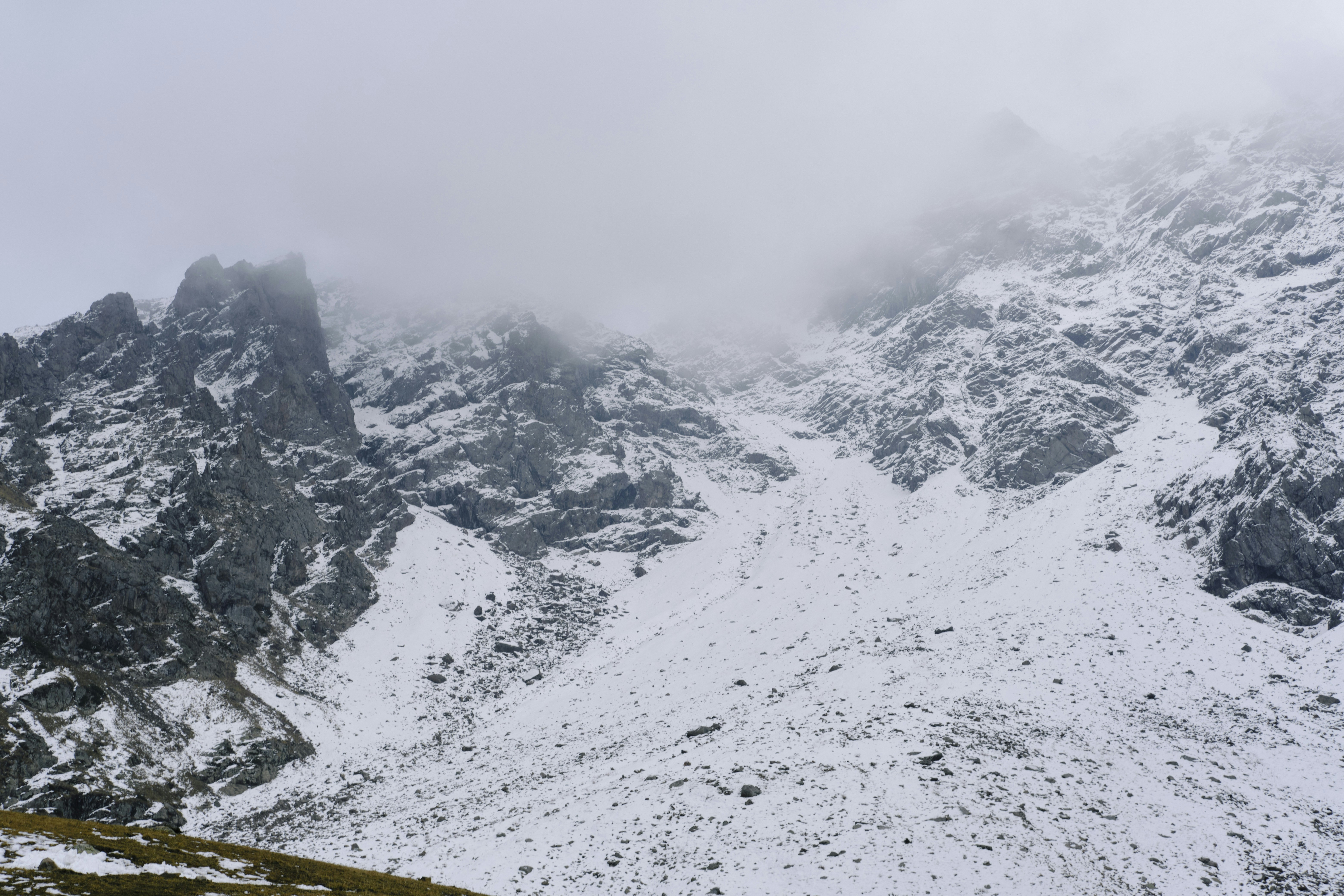 a mountain covered in snow and clouds, 