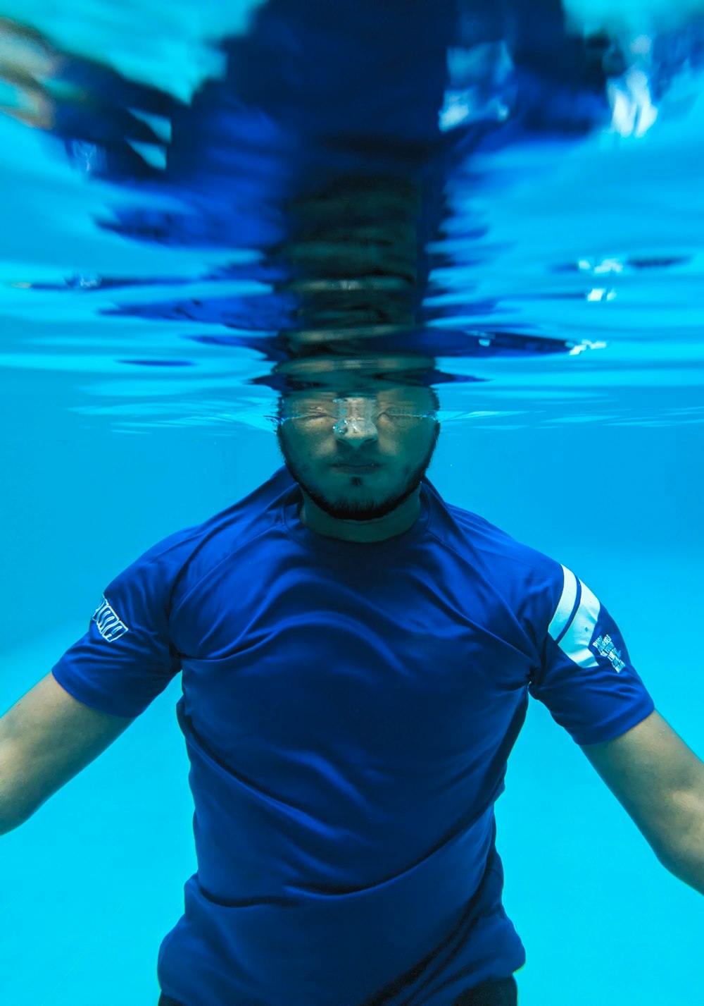 Ein Mann in einem blauen Hemd unter Wasser