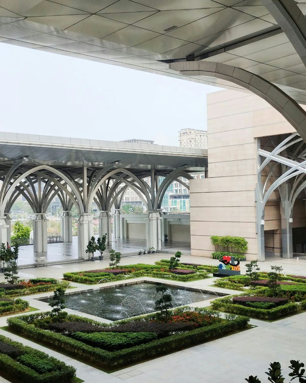 a courtyard with a fountain surrounded by greenery