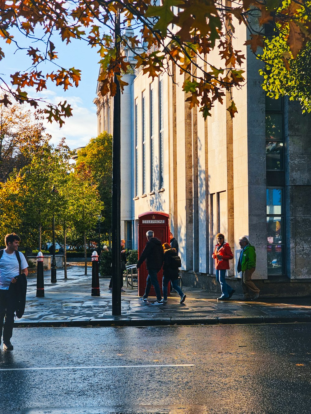 a group of people walking down a street next to a tall building