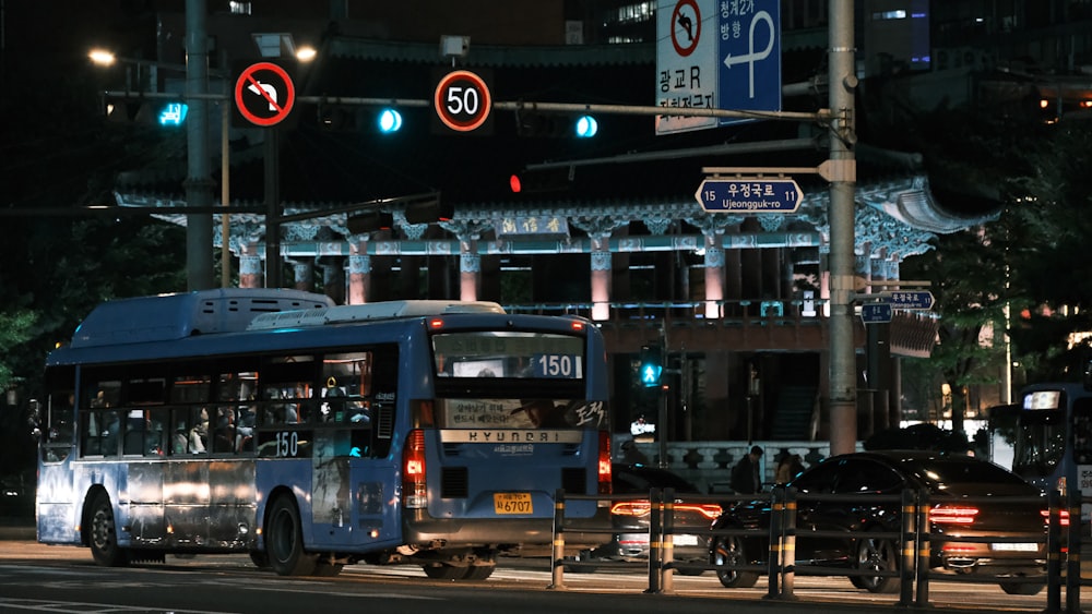 Un bus bleu roulant dans une rue la nuit