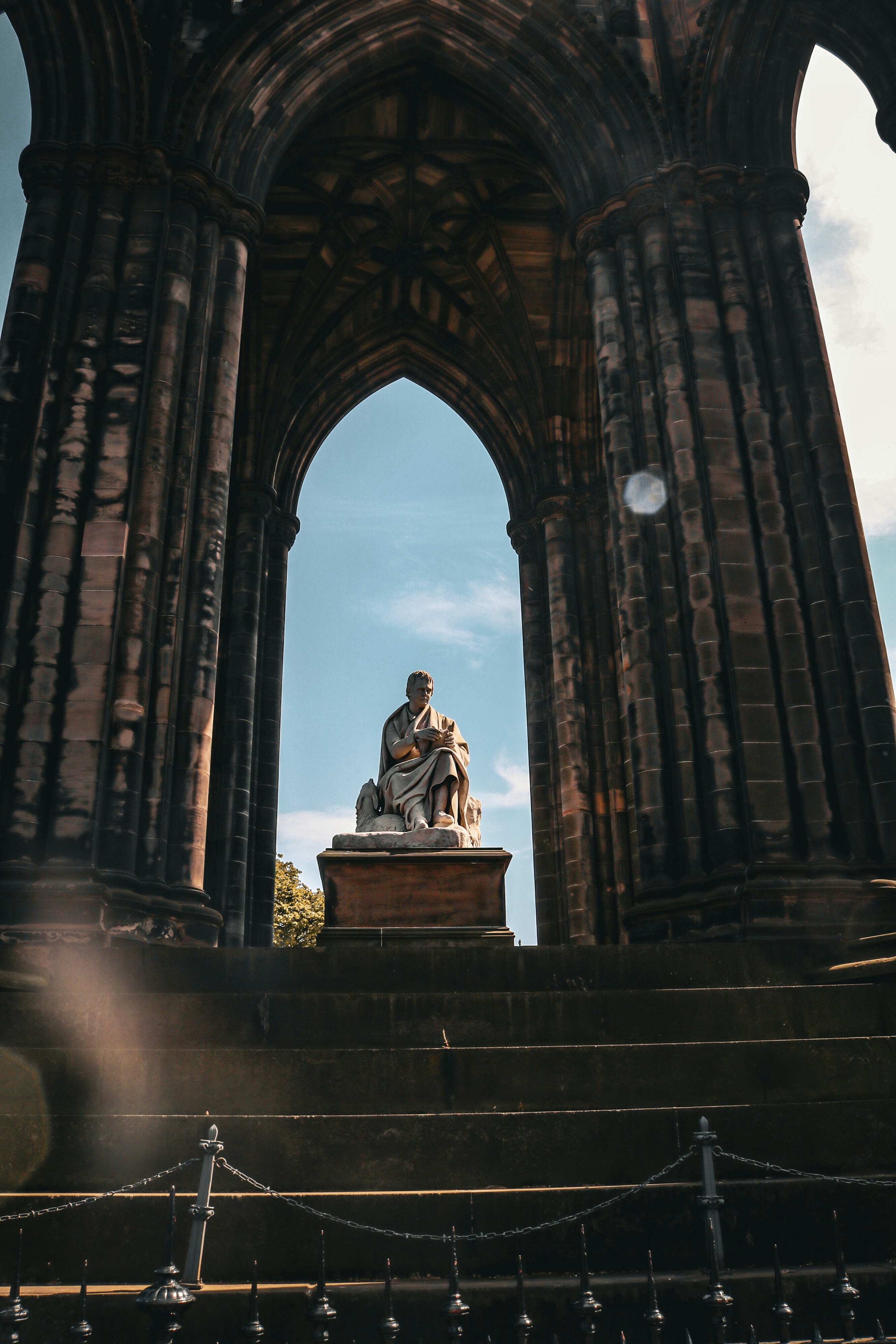 a statue of a man sitting on top of a bench