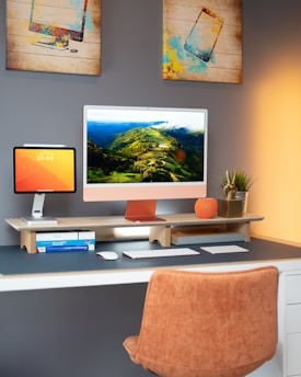 a desk with a computer monitor, keyboard and mouse