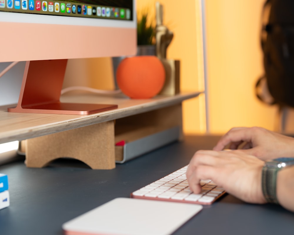 a person typing on a keyboard at a desk