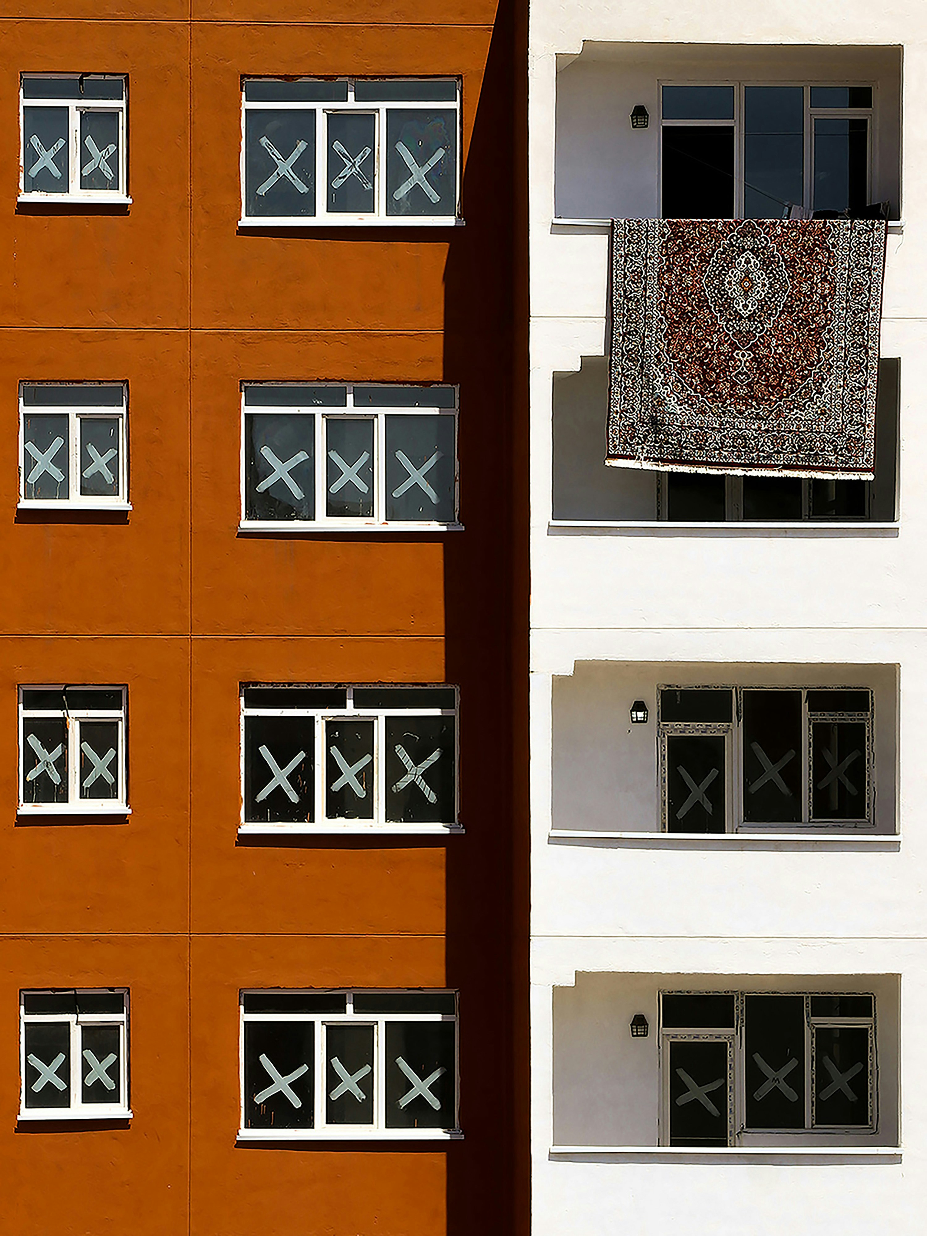 un bâtiment avec une fenêtre et un tapis suspendu à la fenêtre