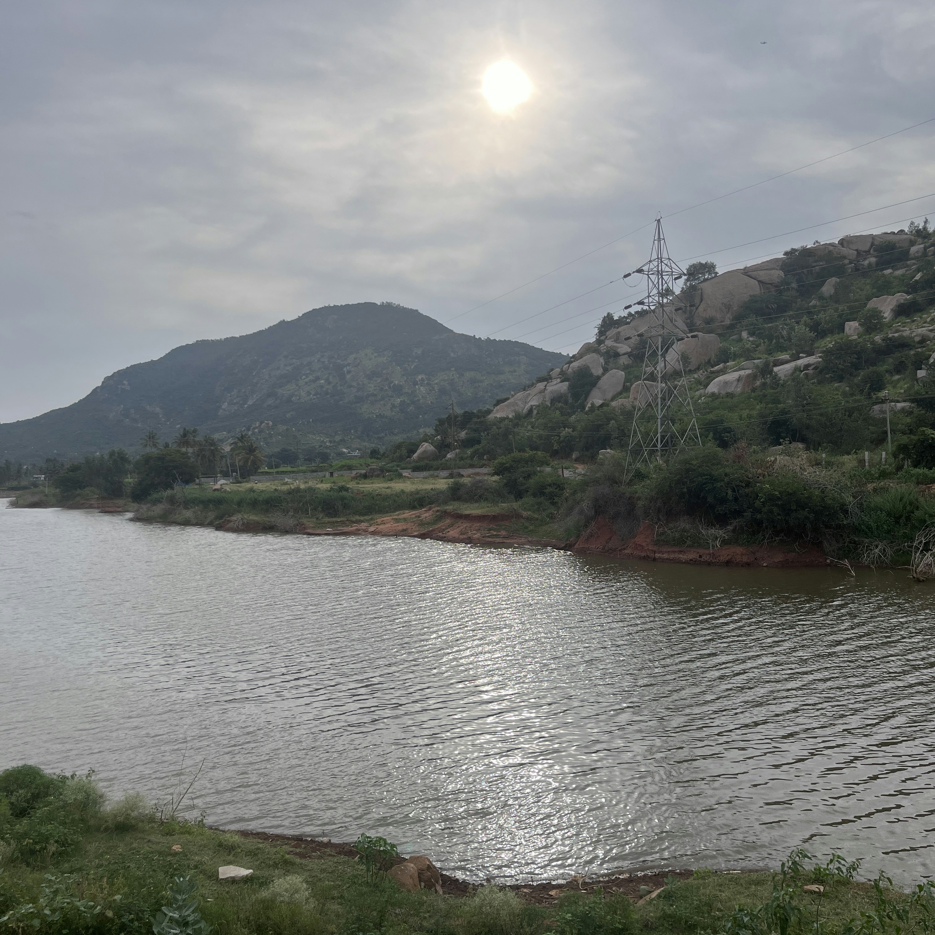 a body of water with a hill in the background