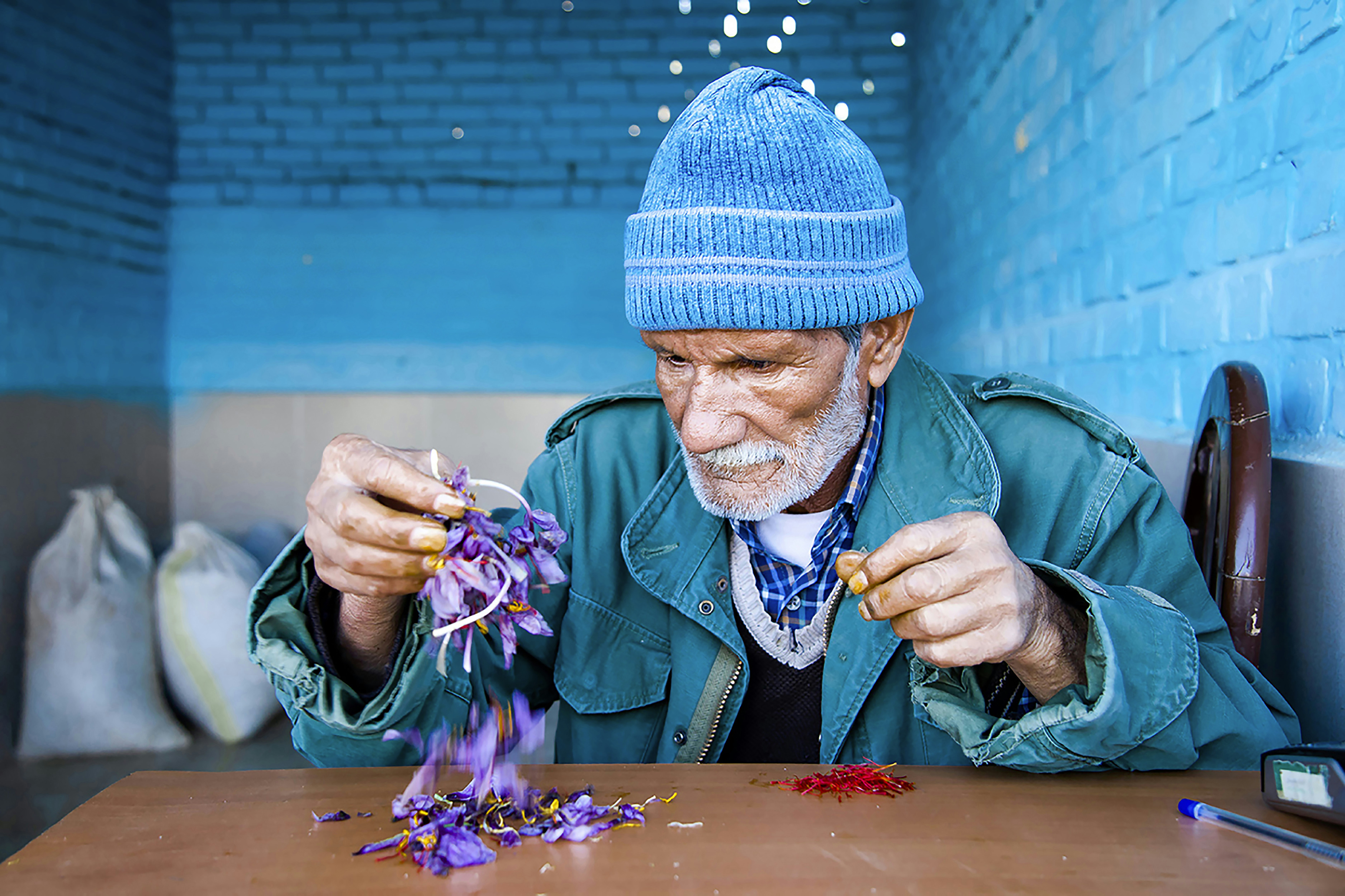 Un homme au chapeau bleu fait des fleurs