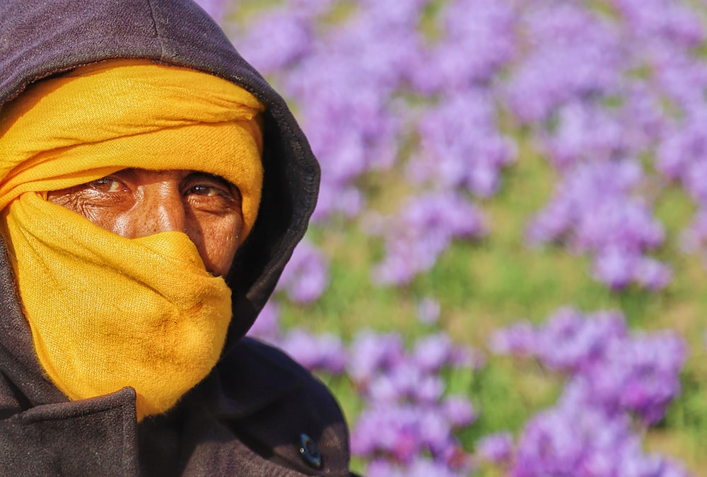 a man with a yellow scarf covering his face